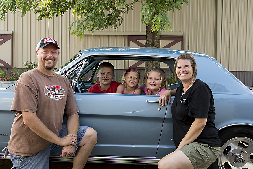 Kristi O'Shea's family posing with her 67 Mustang.